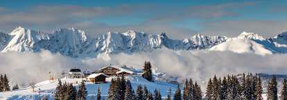 Photo of the top of a ski resort in Megève in France with snowy mountains in the background