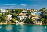 View of Menorca shores in the Balearic Islands with chalets and turquoise sea during summer
