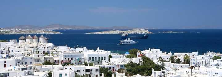White house with Mediterranean sea in background and a yacht and an ocean liner in summer