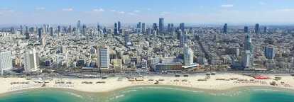 Foto von Tel Aviv in Israel mit einem Strand im Vordergrund und Wolkenkratzern im Hintergrund