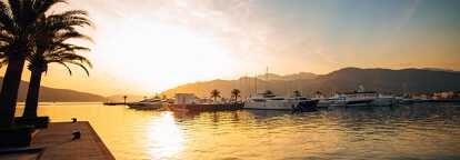 Sunset in Porto Montenegro in Tivat with palm trees and yachts in the bay of Kotor