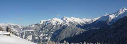 Photo des montagnes enneignés de Zurs en Autriche avec un chalet sur la gauche