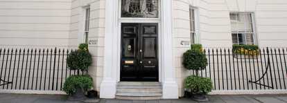 Front entrance black wooden door of LunaJets' office at 42 Berkely Square in London United Kingdom