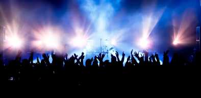 Music concert with a drum enligthened by purple and blue lights and people waving hands Music concert with a drum enligthened by purple and blue lights and people waving hands