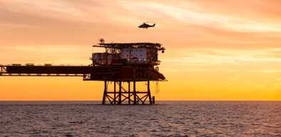 Helicopter taking off from an oil or gas platform in the middle of the sea