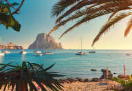 Famous, empty and beautiful Cala d'Hort beach, in summer very popular, sandy coast have a fantastic view of mysterious island of Es Vedra. Moored vessels on bay. Ibiza Island, Balearic Islands. Spain
