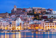 Ibiza Dalt Vila downtown at night with light reflections in the water, Ibiza, Spain.
