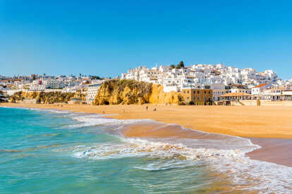 Wide sandy beach in white city of Albufeira, Algarve, Portugal
