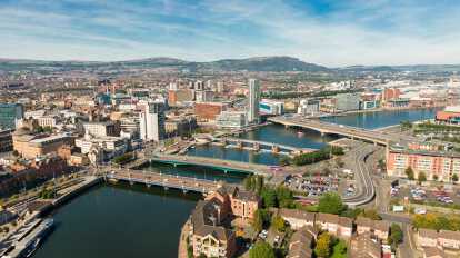Vista aérea sobre el río y los edificios en el centro de la ciudad de Belfast, Irlanda del Norte. Foto de drone, vista de ángulo alto de la ciudad