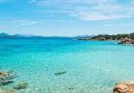 Costa Esmeralda in Olbia mit klarem, transparentem, türkisfarbenem Wasser an einem ruhigen, sonnigen Sommertag