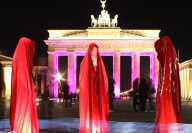 Five red silhouettes and lightning effects at Festival of lights in Berlin at Brandenburg Gate Five red silhouettes and lightning effects at Festival of lights in Berlin at Brandenburg Gate