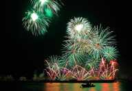Fireworks at the Geneva Festival with the silhouette of a boat on the lake Léman Fireworks at the Geneva Festival with the silhouette of a boat on the lake Léman
