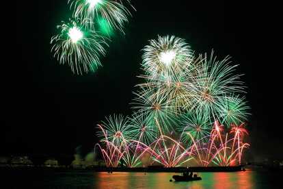 Fireworks at the Geneva Festival with the silhouette of a boat on the lake Léman