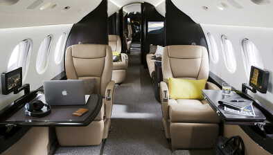 Cabine luxueuse du Falcon 7X avec sièges et ordinateur portable