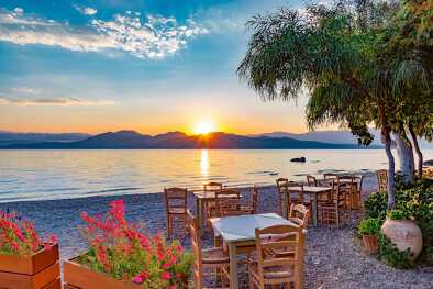 Tavoli e sedie sulla spiaggia di Lefkada all'alba