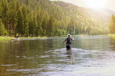 Рыбак ловит рыбу нахлыстом в реке штата Монтана

