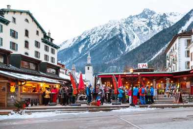 Открытый бар во время "счастливого часа" и люди, отдыхающие после катания на лыжах в городе Шамони во Французских Альпах, Франция