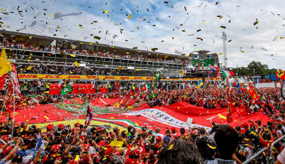 Red Ferrari formula one racing car during the Italian F1 Grand Prix in sunlight
