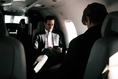 Hombre de negocios hablando por teléfono a bordo de un avión privado