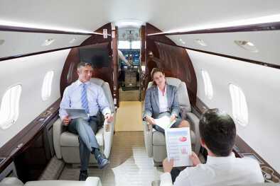 Los ejecutivos de negocios celebran una reunión de negocios privada en una cabina de jet privado