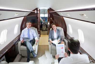 Business executives hold a private business meeting in a private jet cabin