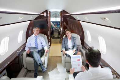 Business executives hold a private business meeting in a private jet cabin Business executives hold a private business meeting in a private jet cabin