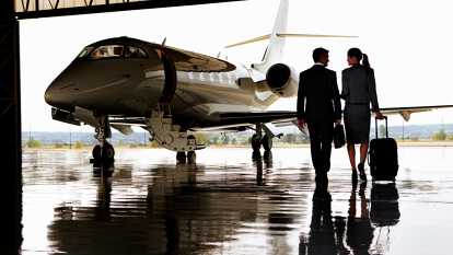2 people heading to the cabin of a private jet