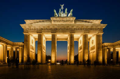 La Puerta de Brandeburgo iluminada en Berlín con algunas sombras fugaces de berlineses anónimos - Símbolo de Alemania.