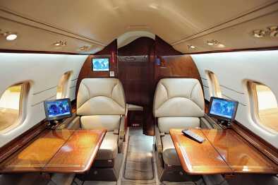 The luxurious cabin of a private jet with built-in TV and computer screens