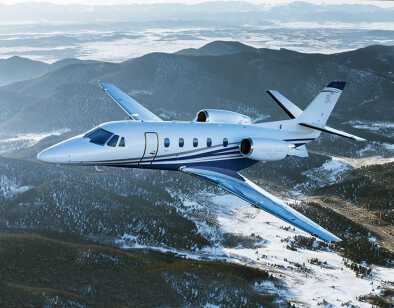 Citation XLS+ in flight over snowy forest landscape