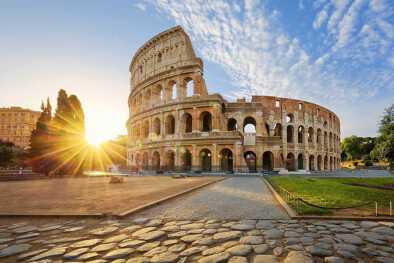 Vista del Coliseo en Roma y sol matutino, Italia, Europa.
