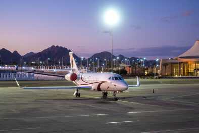 A private jet waits on a runway at sunset A private jet waits on a runway at sunset