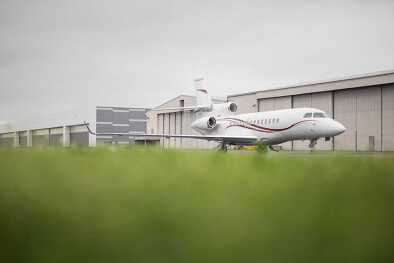 Un Falcon 7X garé à côté du hangar à avions Un Falcon 7X garé à côté du hangar à avions