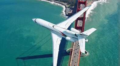 A Dassault Falcon 8X in flight over a four-lane highway bridge A Dassault Falcon 8X in flight over a four-lane highway bridge