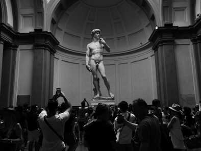 Tourists look at David by Michelangelo in Academy of Fine Arts of Florence. Italy.