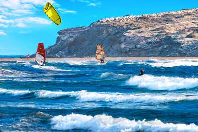Dos windsurfistas y kitesurfistas montan en la playa de Prasonisi (Rodas, Grecia)