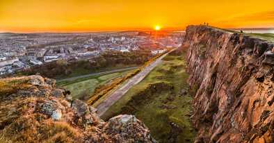 Puesta de sol sobre la ciudad de Edimburgo en el monumento al rey arturo