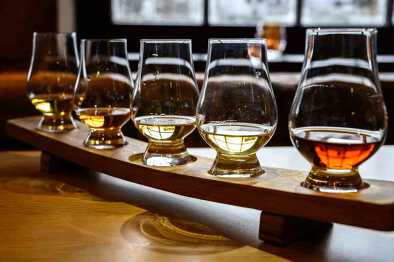 Juego de whisky escocés, vasos de degustación con una variedad de maltas individuales o licores de whisky mezclados en una gira de destilería en Escocia, Reino Unido