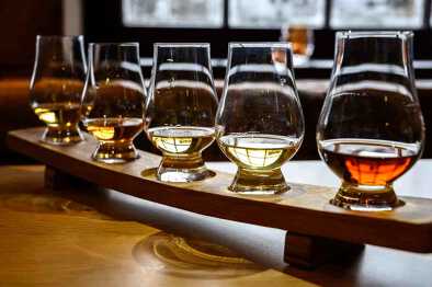 Juego de whisky escocés, vasos de degustación con una variedad de maltas individuales o licores de whisky mezclados en una gira de destilería en Escocia, Reino Unido Juego de whisky escocés, vasos de degustación con una variedad de maltas individuales o licores de whisky mezclados en una gira de destilería en Escocia, Reino Unido