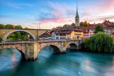 Centro storico della città di Berna, tetti di tegole, ponti sul fiume Aare e campanile della chiesa in un drammatico tramonto, Svizzera