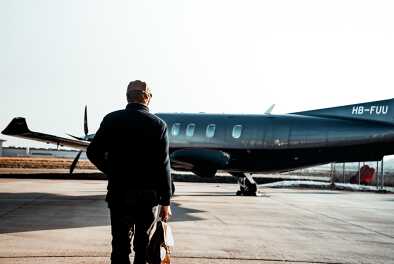 Geschäftsmann, der sich für seine nächste Reise einem Privatjet nähert Geschäftsmann, der sich für seine nächste Reise einem Privatjet nähert