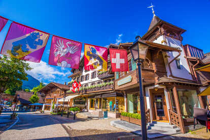 Skyline of Gstaad in Switzerland with rooftops covered in snow and mountains