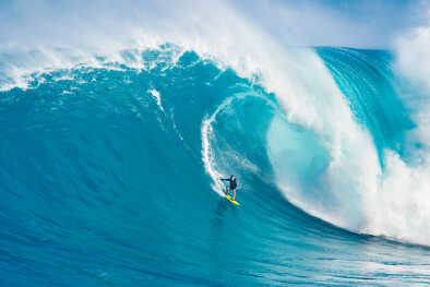 Un uomo che fa surf su un'onda enorme