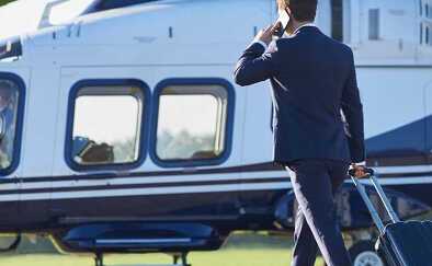 A businessman walking towards an helicopter 