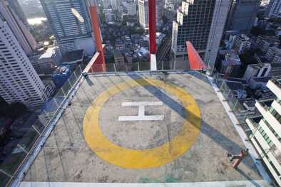 A helipad on top of a roof in a busy urban district 