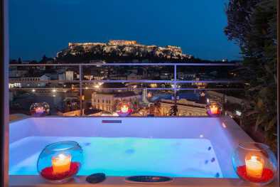 una piscina con vistas a una ciudad y un gran edificio al fondo en el hotel a for atehns una piscina con vistas a una ciudad y un gran edificio al fondo en el hotel a for atehns