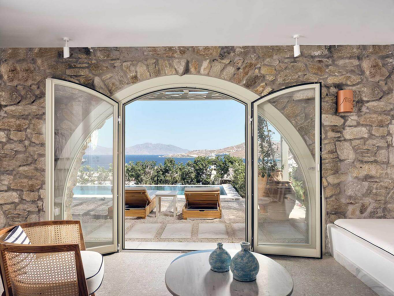 un arrière-plan de Mykonos pour votre excursion estivale. Les Hilltop Rooms & Suites sont une collection éclectique de logements opulents de style résidentiel pour le touriste qui veut vivre comme un local. Elles sont situées au sommet d'une colline ondulée et offrent une vue imprenable sur l'ensemble de l'île.