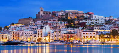 El centro de Ibiza Dalt Vila de noche con reflejos de luz en el agua, Ibiza, España