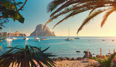 Famosa, vacía y hermosa playa de Cala d'Hort, en verano muy popular, costa de arena tienen una fantástica vista de la misteriosa isla de Es Vedra. Barcos amarrados en la bahía. Isla de Ibiza, Islas Baleares. España Famosa, vacía y hermosa playa de Cala d'Hort, en verano muy popular, costa de arena tienen una fantástica vista de la misteriosa isla de Es Vedra. Barcos amarrados en la bahía. Isla de Ibiza, Islas Baleares. España