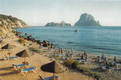 Famous, empty and beautiful Cala d'Hort beach, in summer very popular, sandy coast have a fantastic view of mysterious island of Es Vedra. Moored vessels on bay. Ibiza Island, Balearic Islands. Spain
